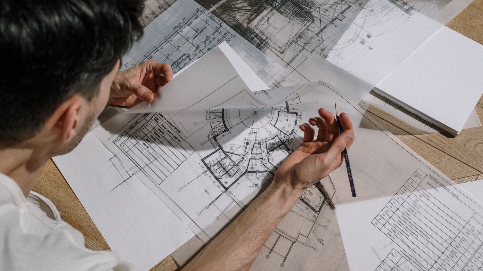 Arquiteto desenhando sobre as plantas do projeto